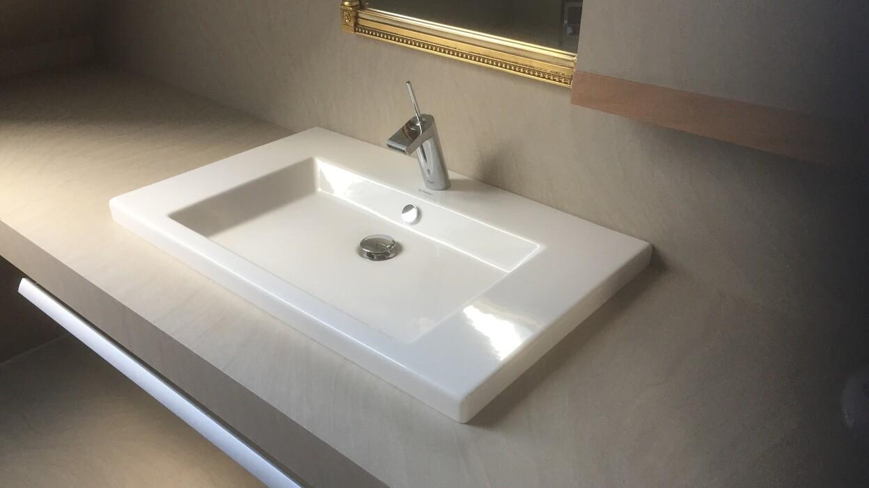 Badmöbel nach Maß Modernes Badmöbel nach Maß mit rechteckigem Waschbecken, Armatur und goldgerahmtem Spiegel.