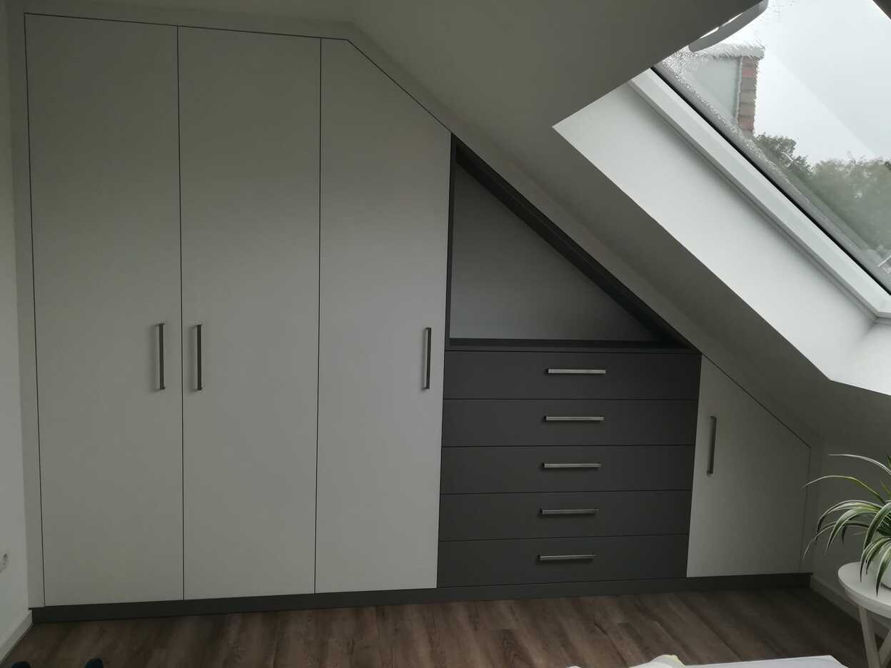 Einbauschrank nach Maß Individueller Einbauschrank nach Maß mit grauen Türen und Schubladen unter Dachschräge.