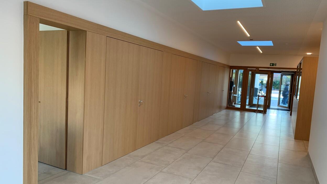 Flur Objekteinrichtung modern Zeitgemäße Objekteinrichtung im Flur mit Einbauschrank, Holzsitzbank und minimalistischer Gestaltung.