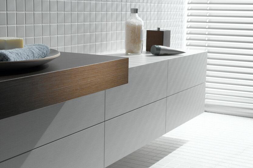 Detailaufnahme eines weißen Waschtischunterschrankes mit dunkler Waschtischplatte