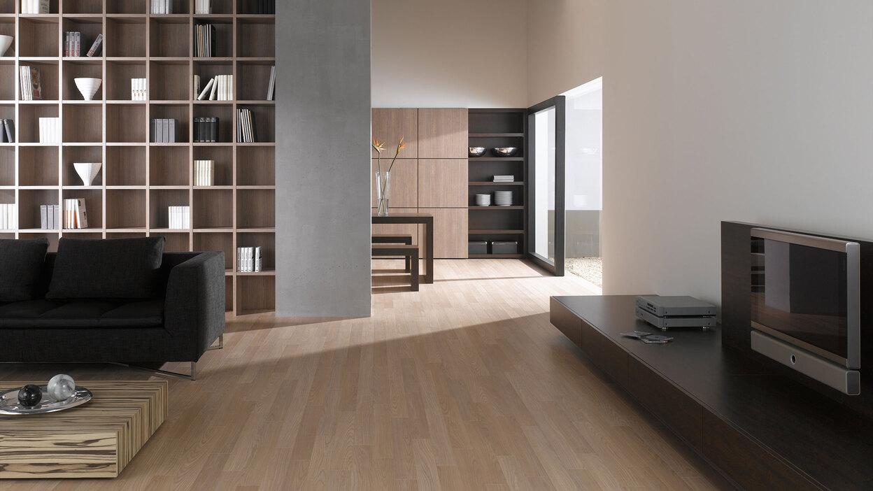 Offene Wohnraumimpression mit Einbauregal f&uuml;r B&uuml;cher und Dekoration in Trennwand mit hellem Holzboden